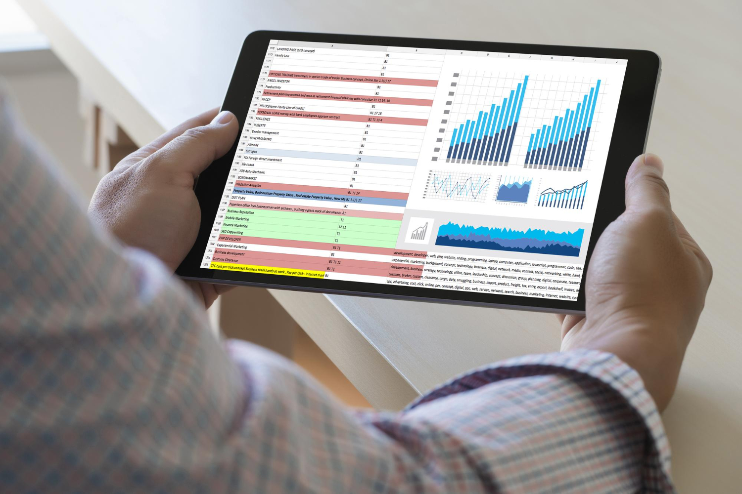 Marketer holding a tablet showing an analytics report with attribution by channel